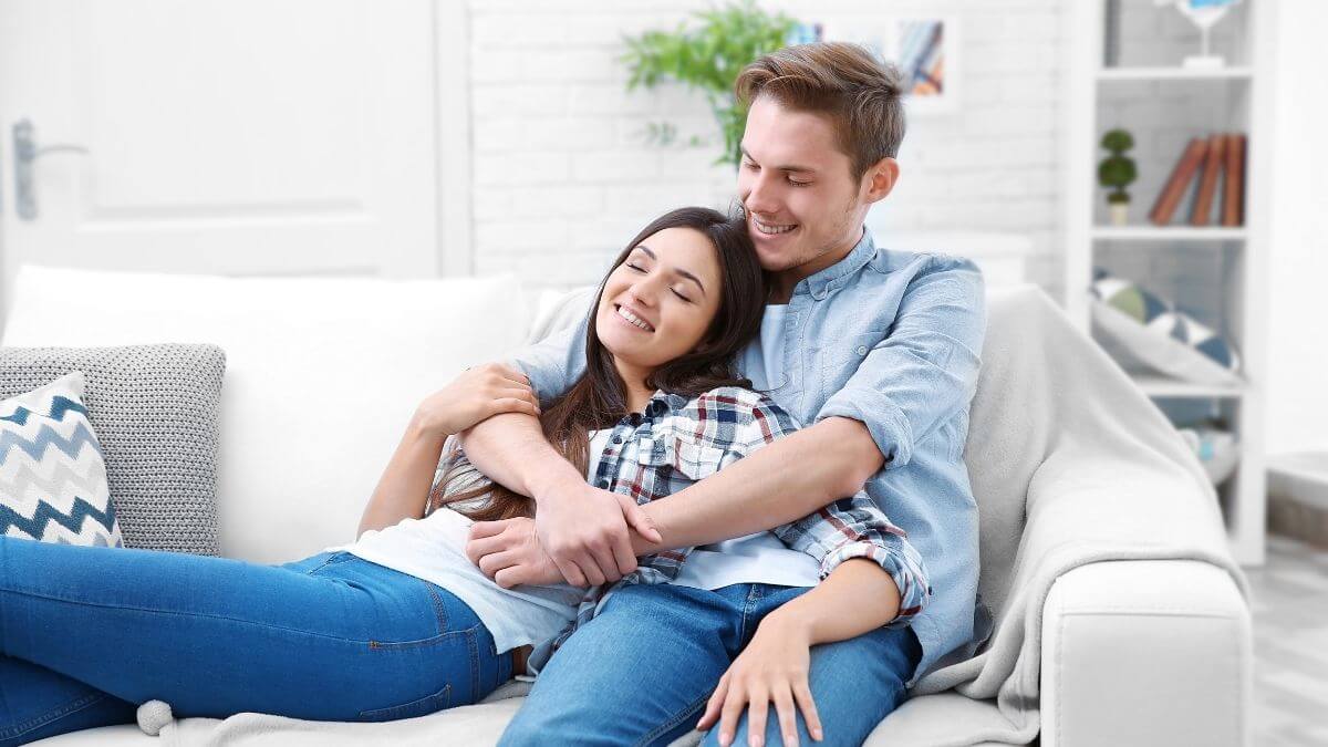 Couple holding each other on the couch